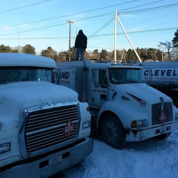 Image of a Cleveland Energy employee on top of a Cleveland Energy truck preparing for a delivery.